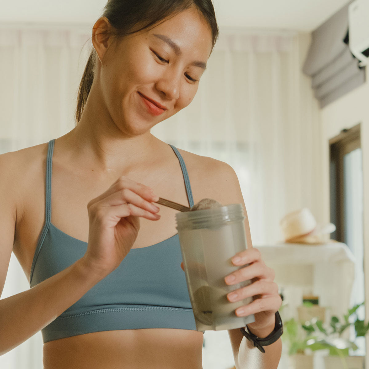 image of person pouring protein powder into a cup