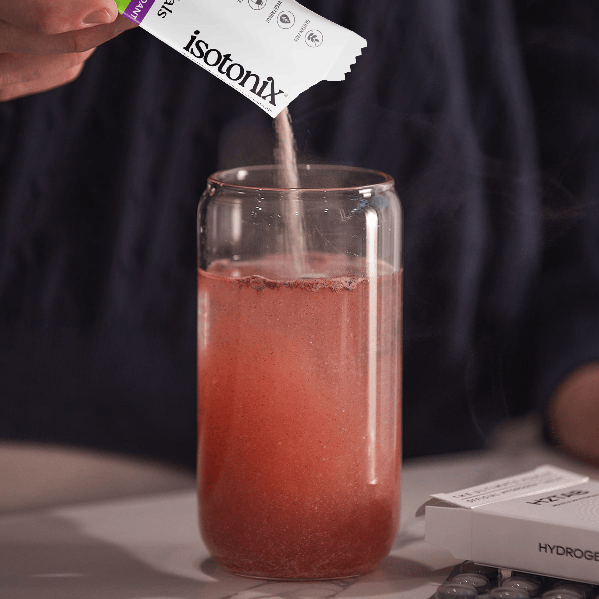 image of person mixing Isotonix Daily Essentials packet into water