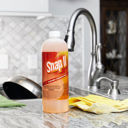 Snap II Cleaner Disinfectant bottle, sitting next to sink containing pots