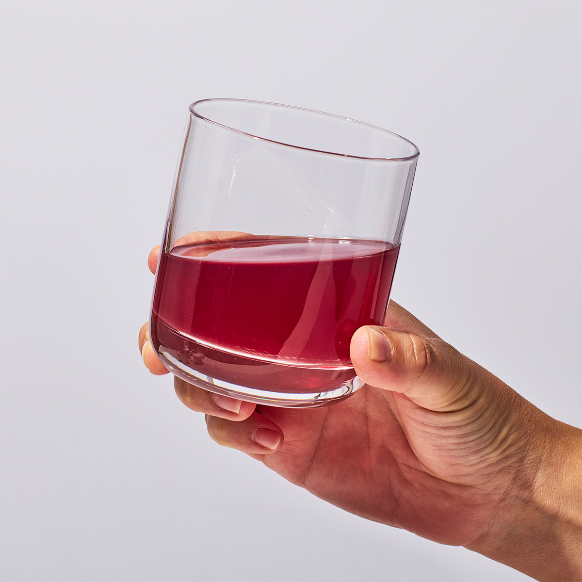 image of a hand holding a glass containing one serving of Isotonix Acai