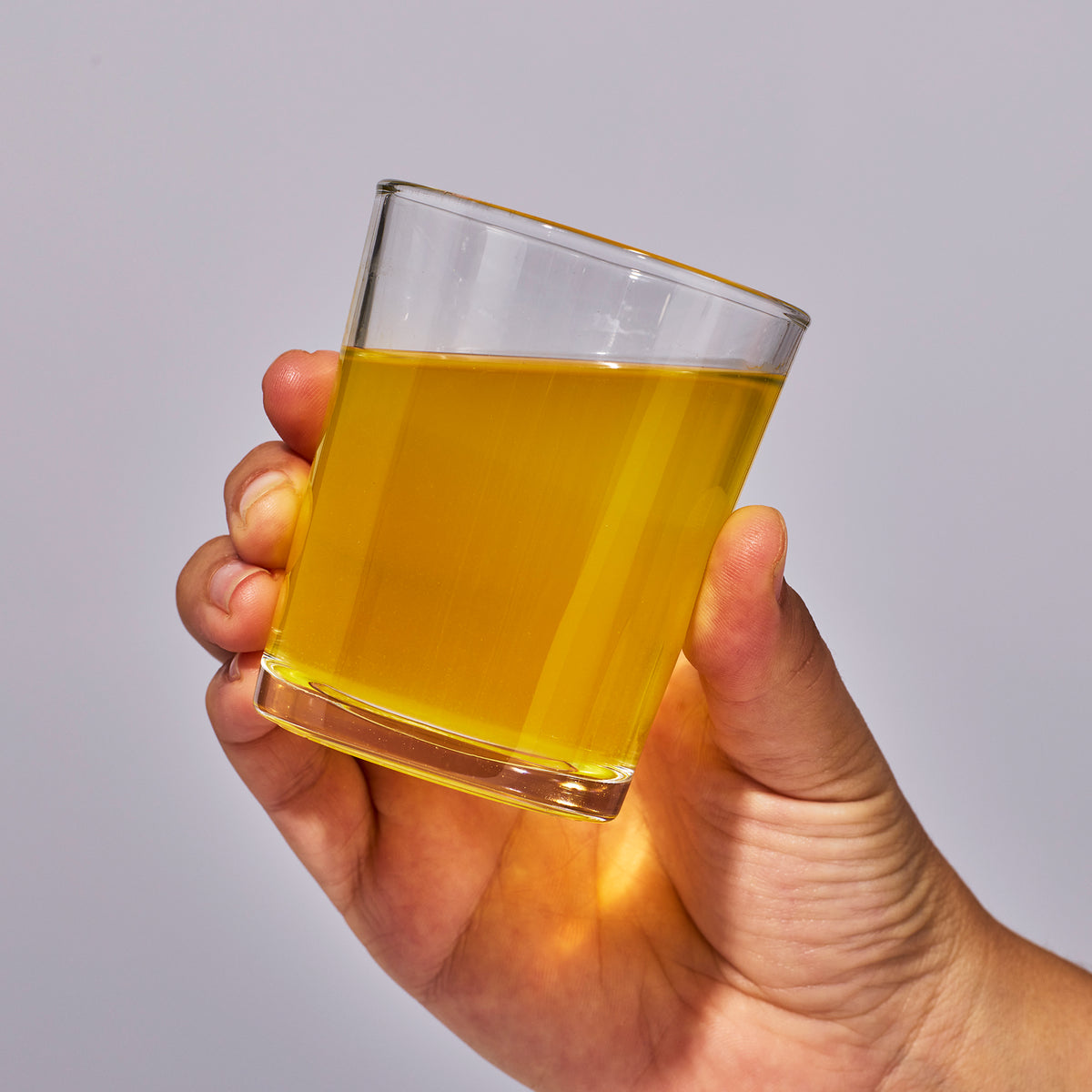 Image of a hand holding a glass containing a serving of Isotonix Multimineral