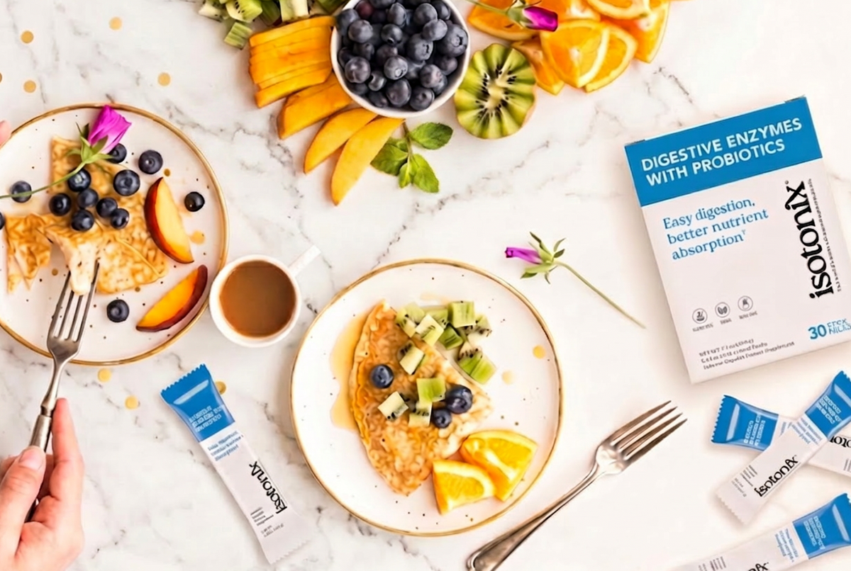 Breakfast scene with pancakes, fruit, and Isotonix digestive enzymes packaging on a marble surface.