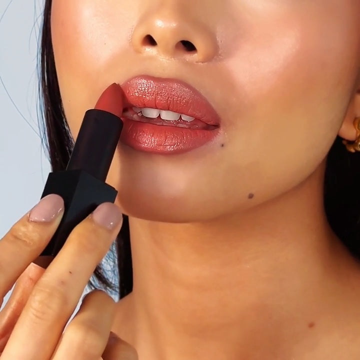 women is applying lipstick