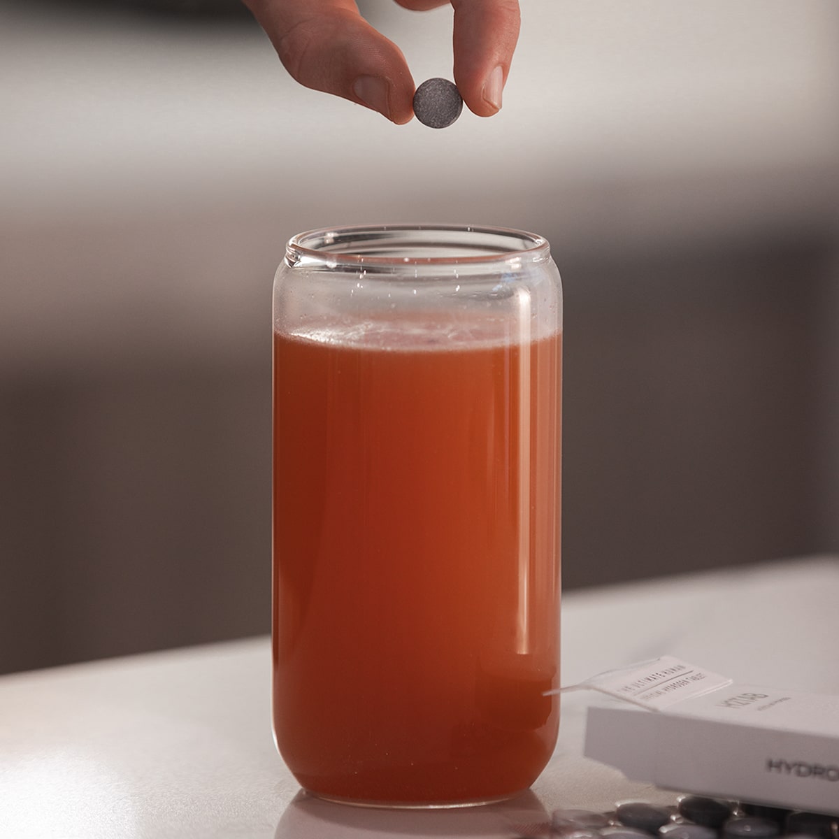 image of person dropping one H2TAB into the cup