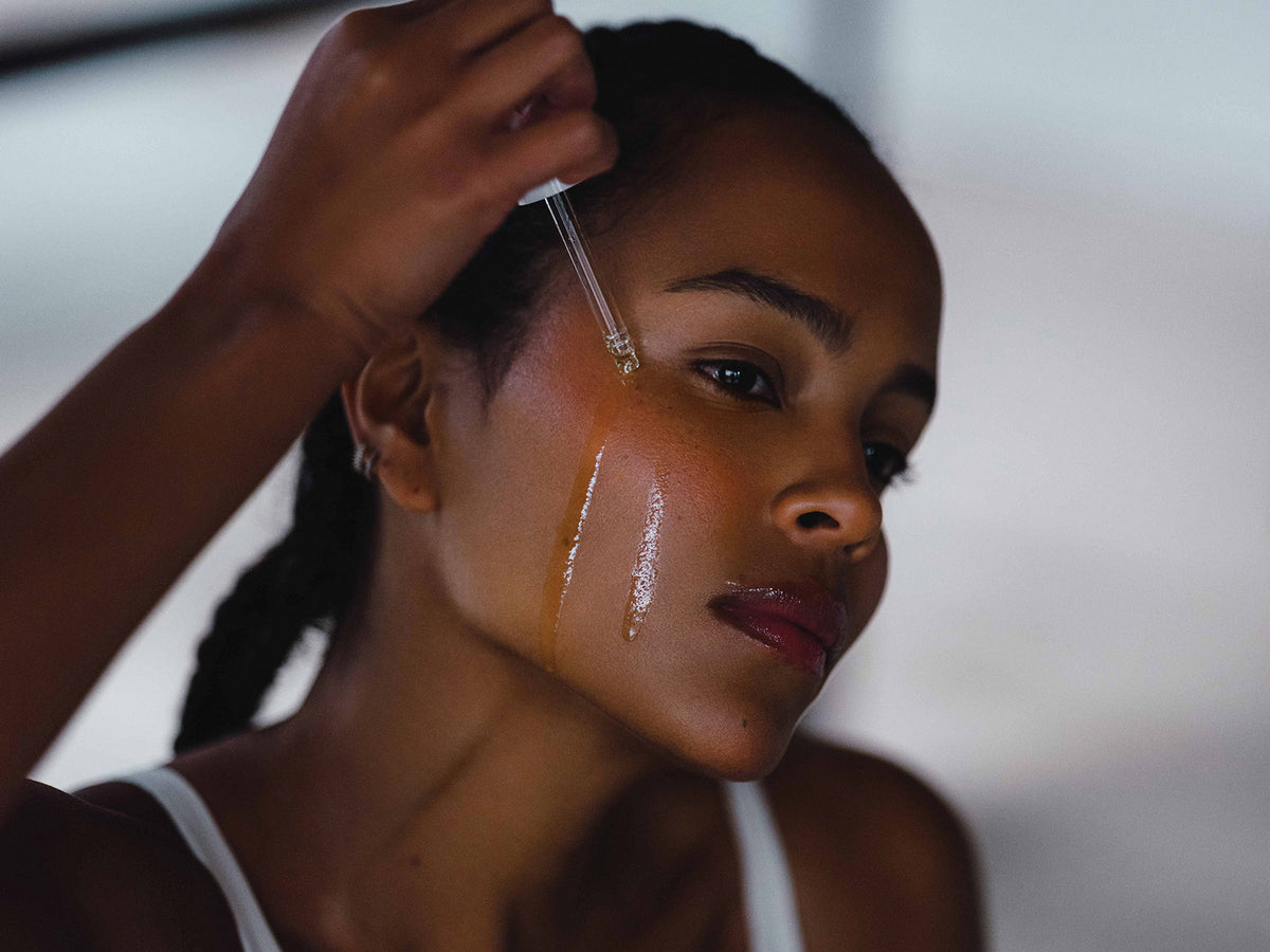 Woman applying serum to her face