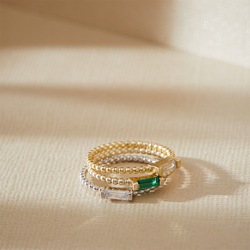 Three Layered Adrienne - Spiraled Baguette Rings in silver and gold, with clear and green gems, stacked