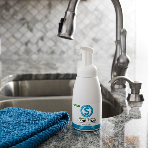 Shopping Annuity Brand Organic Foaming Hand Soap on a sink beside a blue towel