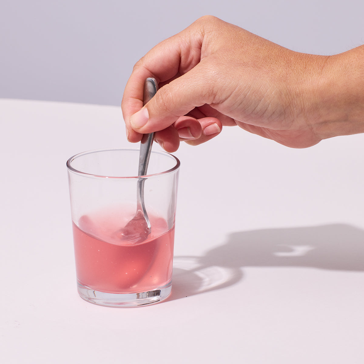Someone mixing up one serving of Isotonix Immune in a glass