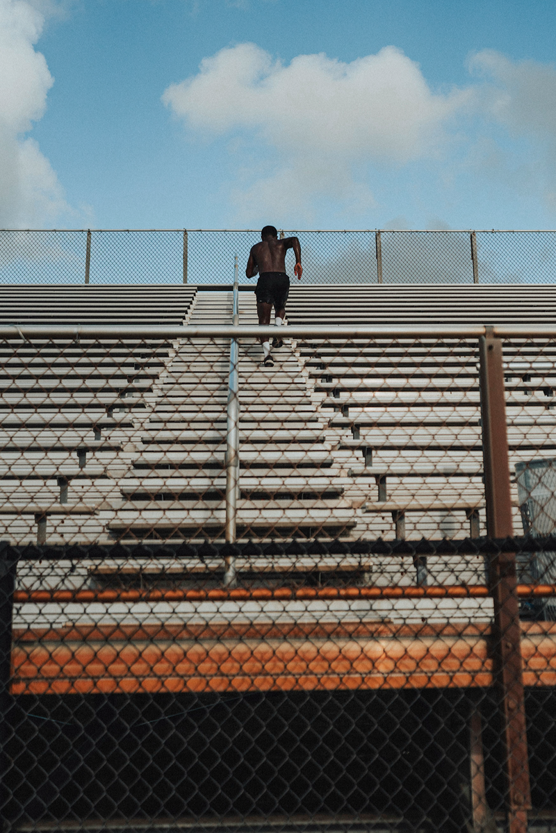 Person standing on a set of bleachers with a clear sky in the background