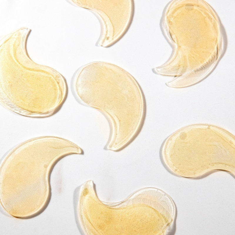 Several translucent pale yellow crescent-shaped gel pads arranged on a plain white background.