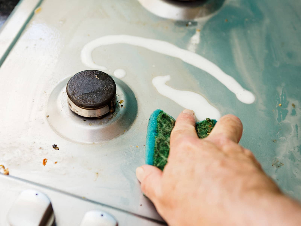 image of someone cleaning the stove