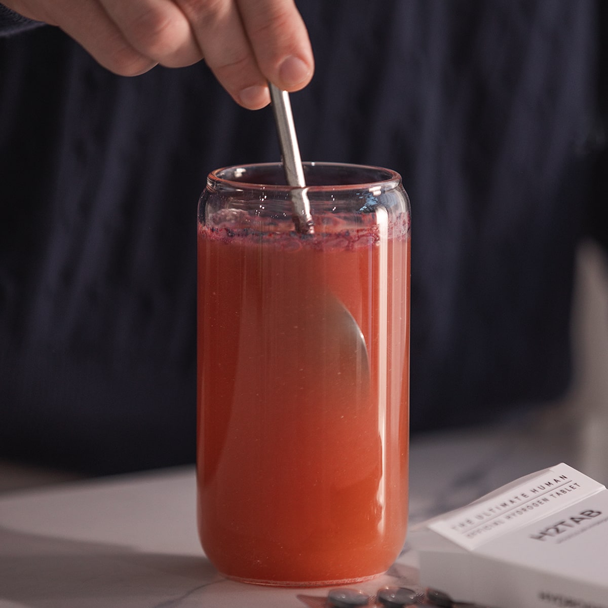 image of person mixing Daily Essentials into the cup