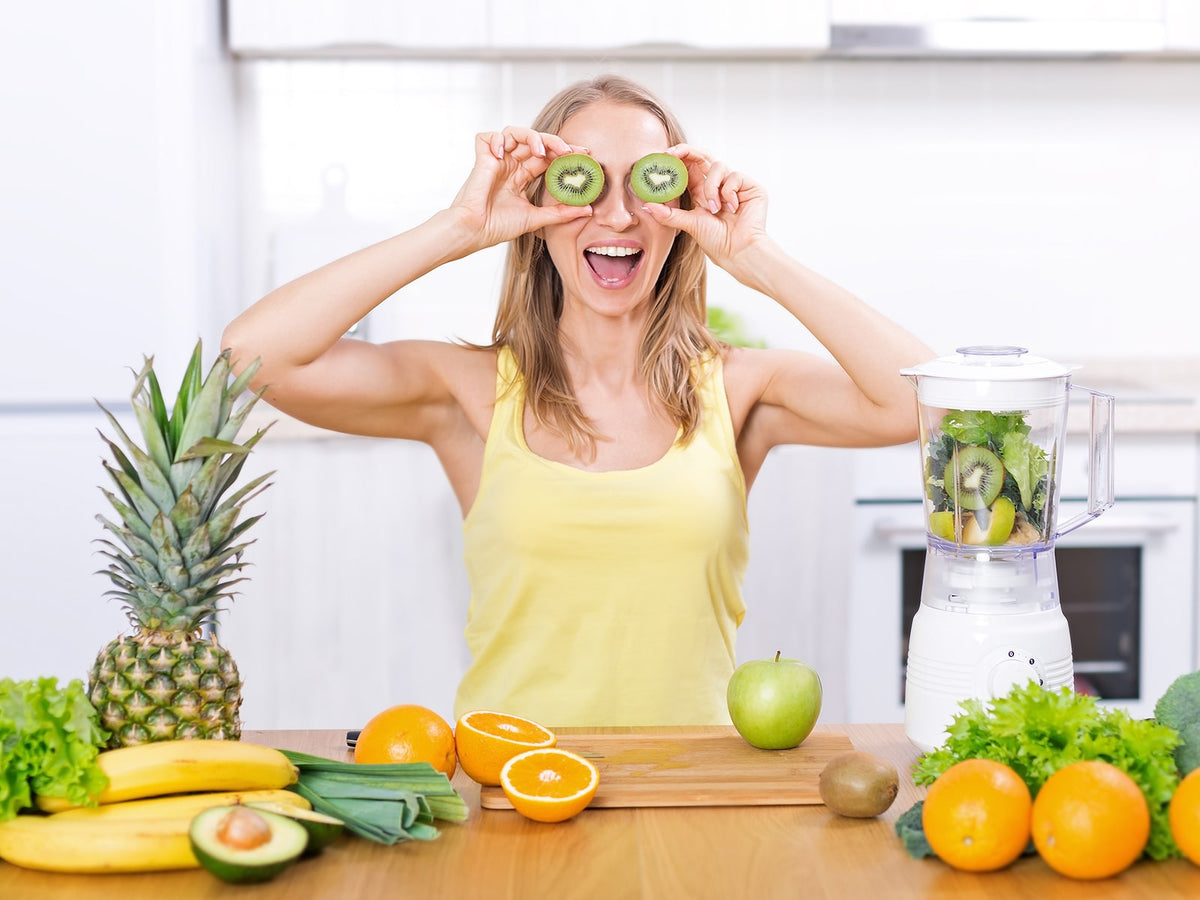 image of a woman holding kiwi's over her face