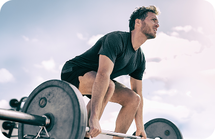 Man lifting weights outdoors with a clear sky background