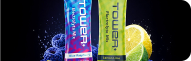 Two Tower+ Electrolyte Mix stick packets, one blue raspberry and one lemon lime, shown with blueberries and a lemon slice on a black background.