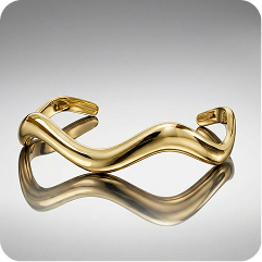 A polished gold abstract wave cuff bracelet with a reflective finish, displayed on a neutral gray gradient background with a soft reflection below.