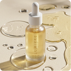 A frosted glass dropper bottle of Umlène Paris 'The Blur' Hyaluronic Serum, filled with pale yellow liquid, set on a reflective beige surface with decorative liquid droplets.