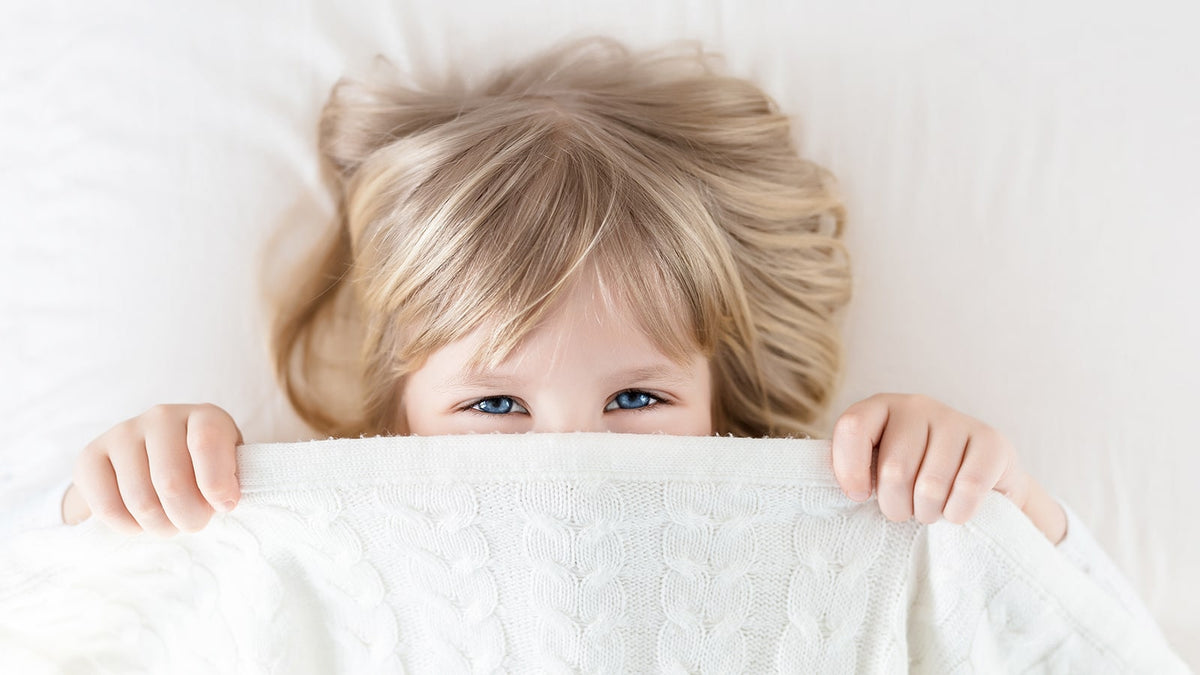 image of a toduler pulling the sheets over their face