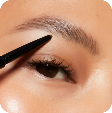 Eyebrow pencil being used on a person's eyebrow