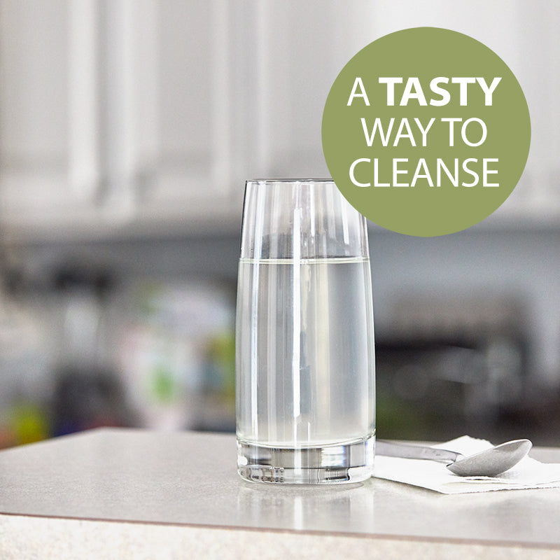 NutriClean Advanced Fiber Powder with Stevia, a tasty way to cleanse, shown mixed in a glass of water on a table with a napkin and spoon