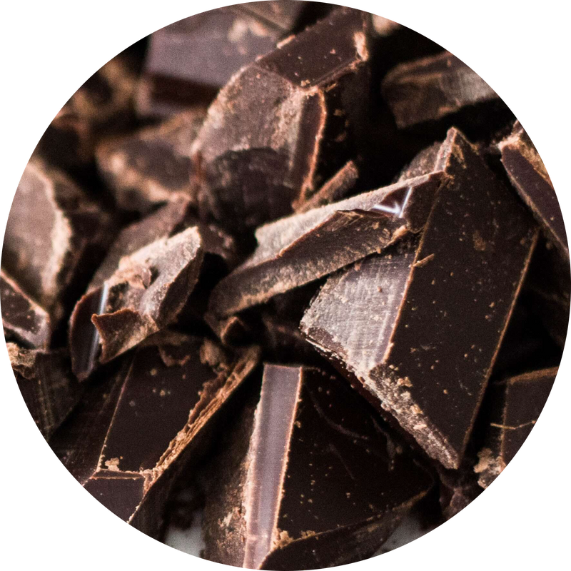 A close-up circular view of broken dark chocolate pieces with glossy and matte surfaces.