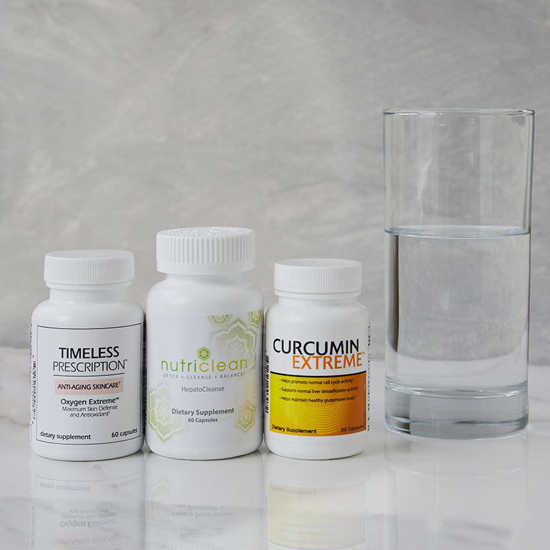 Complete Detoxification Kit: Timeless Prescription Oxygen Extreme™, Curcumin Extreme™, and NutriClean HepatoCleanse, on white table with glass of water