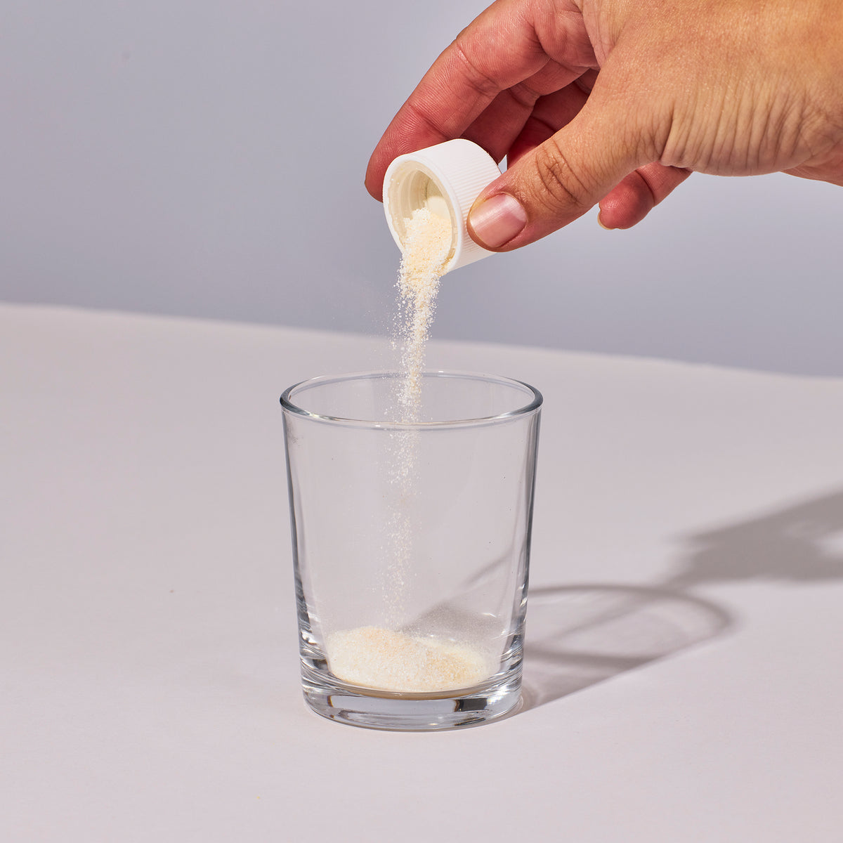 image of someone pouring one serving of Isotonix Multimineral powder into a glass