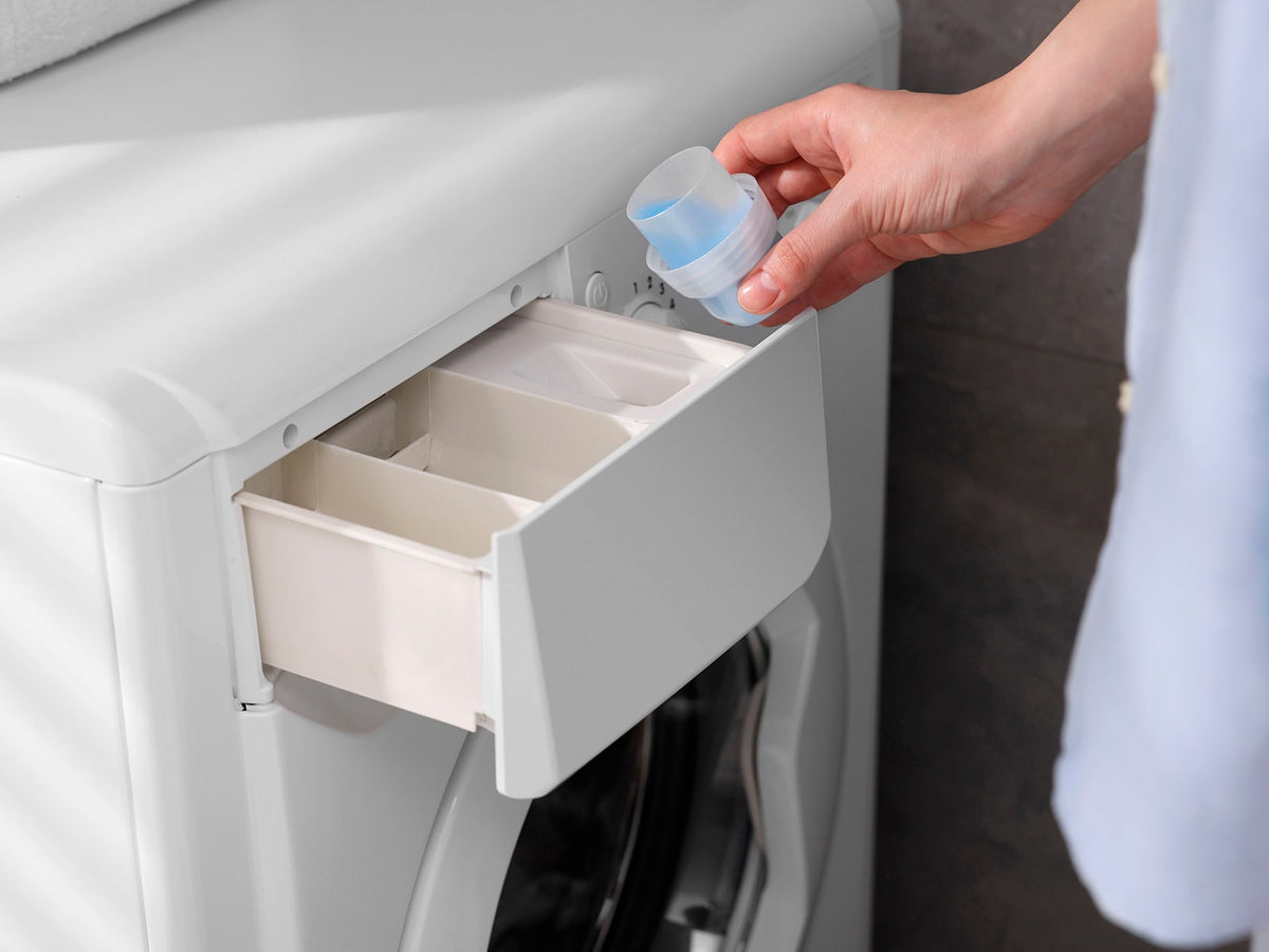 image of person pouring laundry detergent into a washing machine