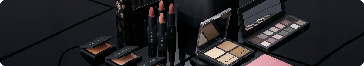 Makeup products including eyeshadows, lipsticks, and a palette on a black surface.