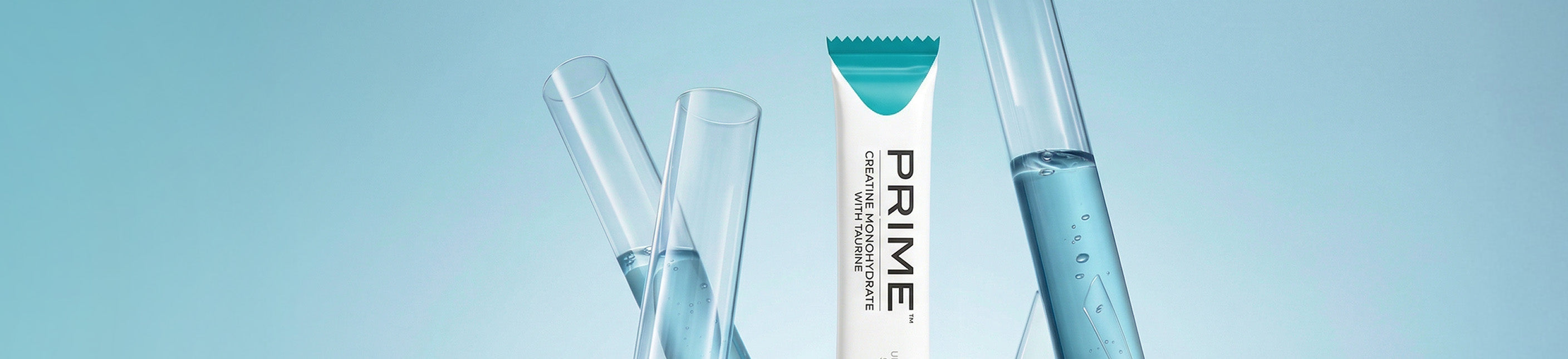 A single white and teal PRIME oral care stick pack stands upright between two clear glass test tubes filled with light blue liquid on a pale blue background.