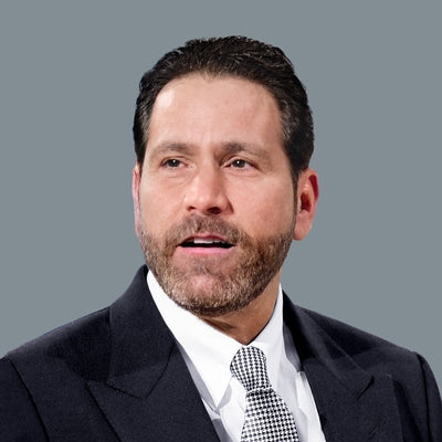 Man wearing a suit and tie against a gray background