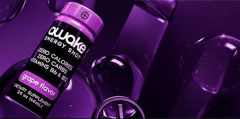A bottle of aluqo Energy Shot drink mix in purple packaging, shown on a dark purple background with abstract glass shapes.