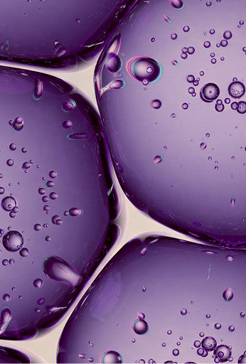 Purple translucent gel beads with embedded air bubbles on a light beige background.
